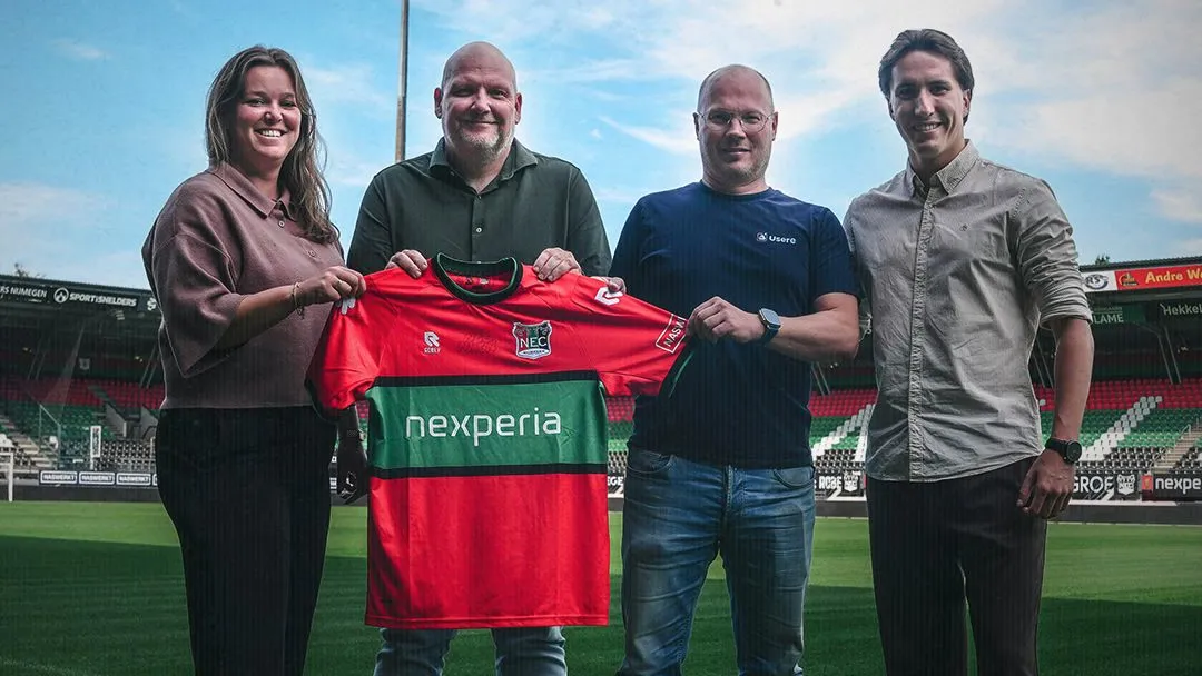 Usere op het veld bij N.E.C. Nijmegen, met het clubshirt in handen